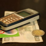 mobile phone money - Erik (HASH) Hersman Mobile Phone with Money in Kenya - CC BY 2.0